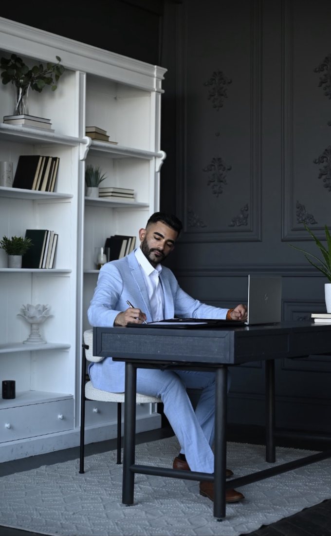 Hammad Mahmud reviewing an offer and paperwork at his desk